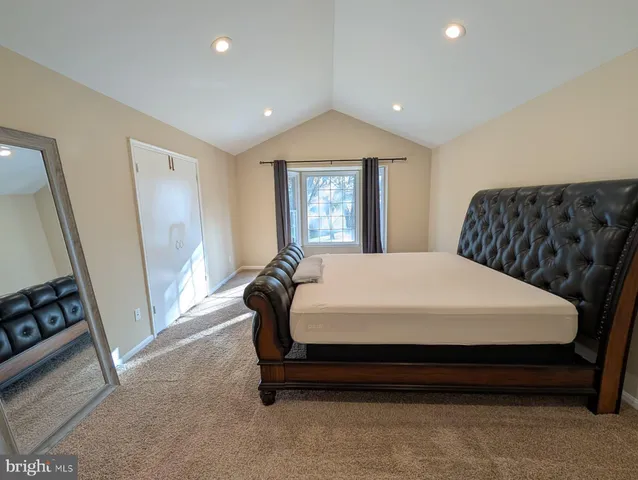 a bed sitting in a spacious bedroom next to a window