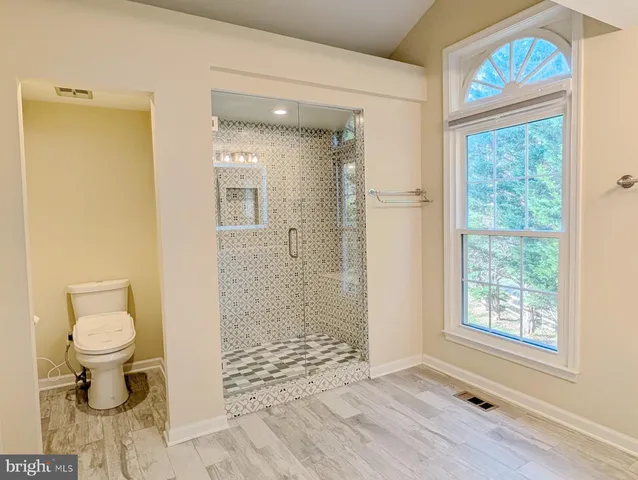 a bathroom with a granite countertop toilet a sink and a shower