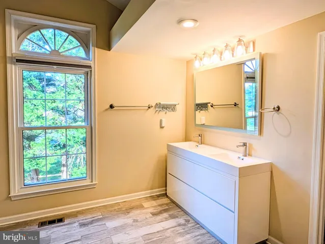 a bathroom with a sink mirror and a bathtub
