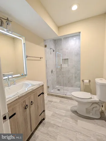 a bathroom with a sink toilet double vanity and shower
