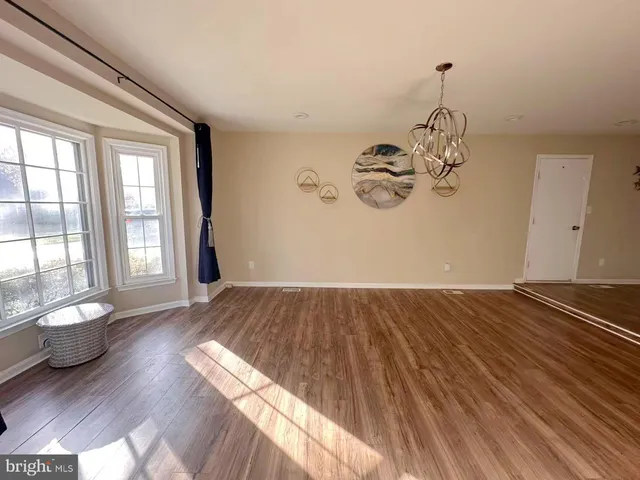 a view of a room with wooden floor and window
