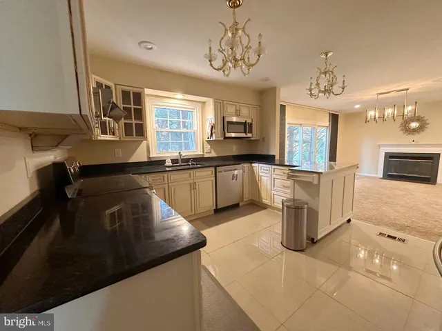 a kitchen with stainless steel appliances granite countertop a sink a stove top oven a counter space and cabinets