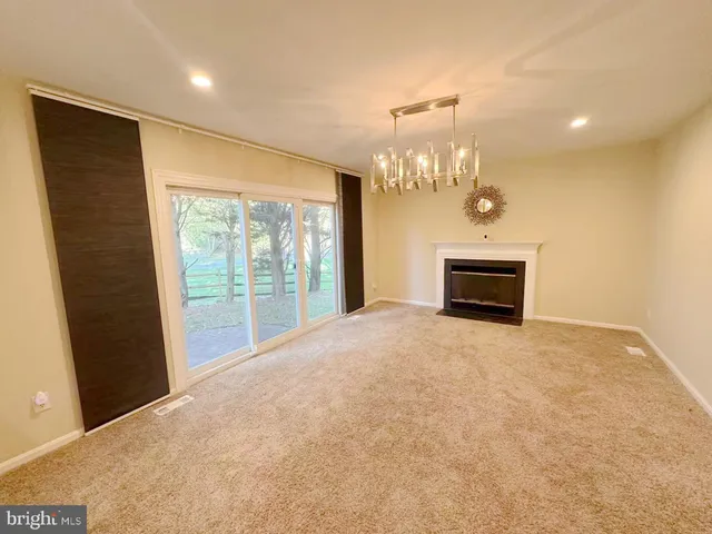a view of empty room with a fireplace and chandelier
