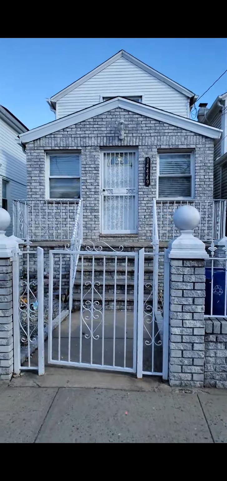 View of front of house featuring a gate and a fenced front yard