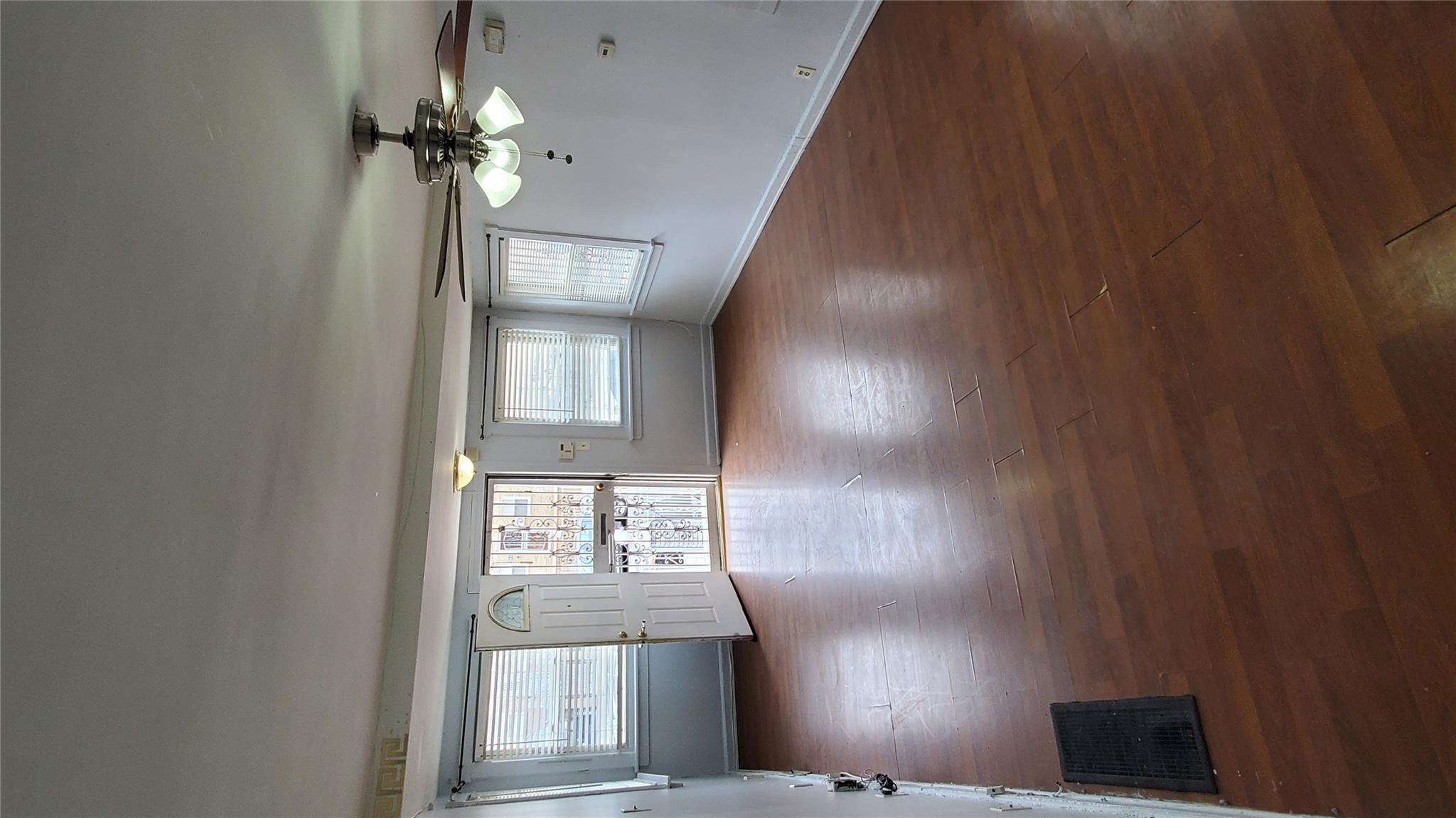 144-49 166th Street Queens, NY 11434 - Photo 13 of 15 Unfurnished room featuring baseboards, visible vents, wood finished floors, and a ceiling fan