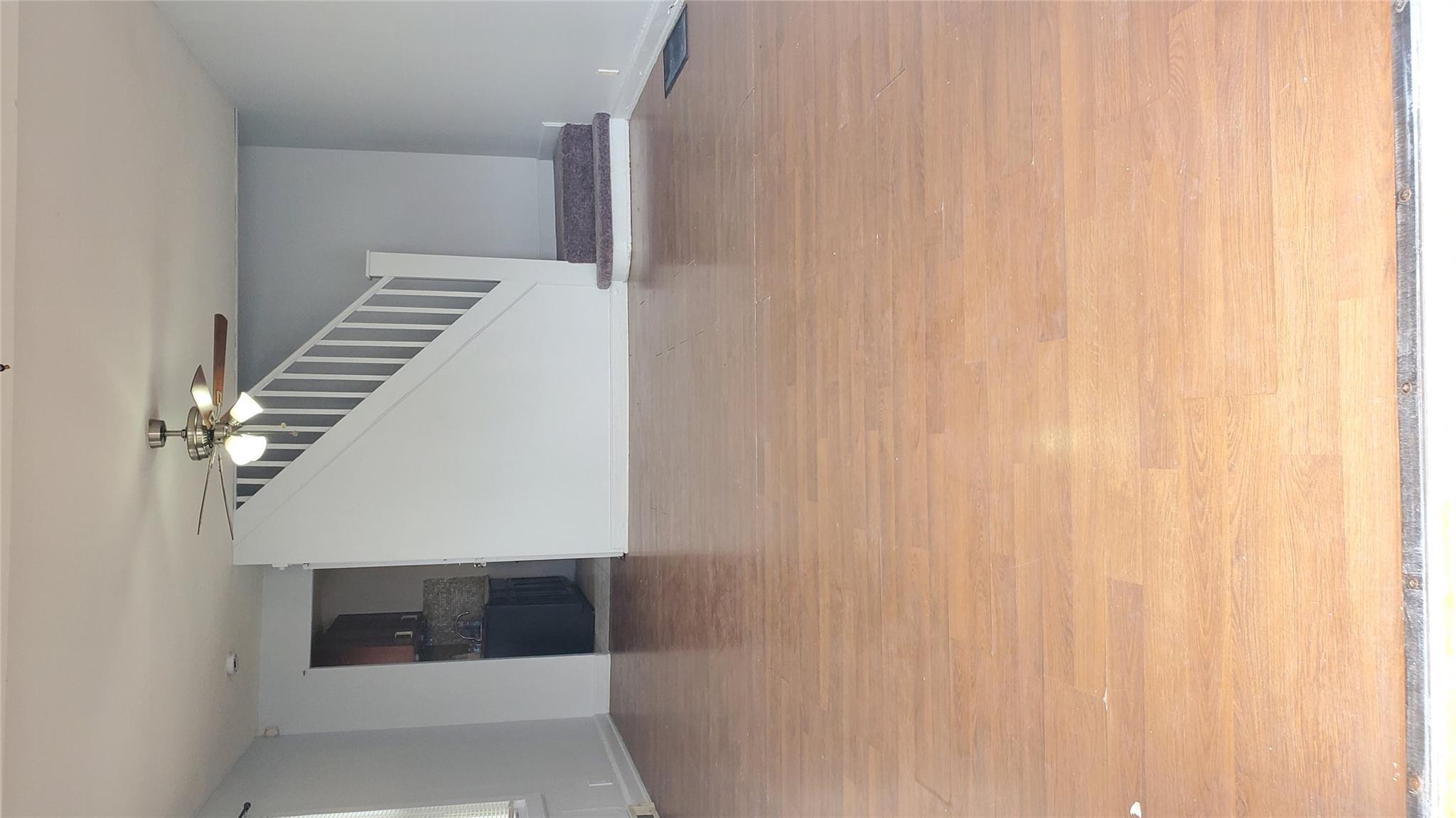 144-49 166th Street Queens, NY 11434 - Photo 2 of 15 Unfurnished living room with baseboards, stairs, wood finished floors, and a ceiling fan