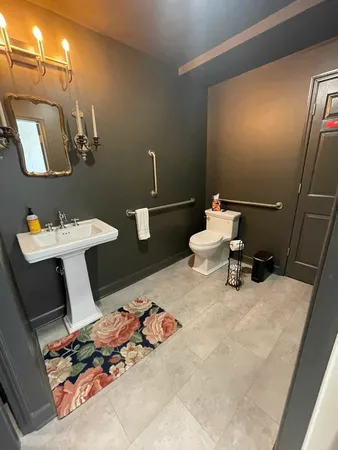 a bathroom with a sink toilet and a mirror