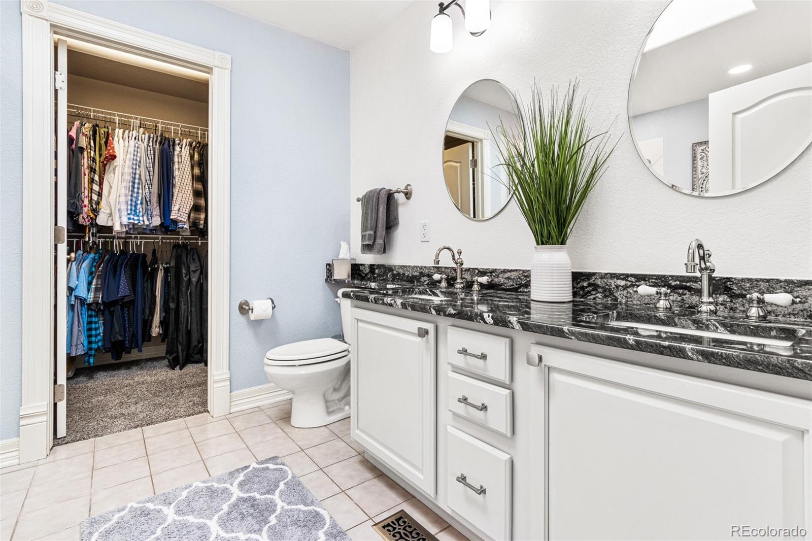 2323 Decatur Street Denver, CO 80211 - Photo 18 of 40 a bathroom with a granite countertop toilet sink and mirror