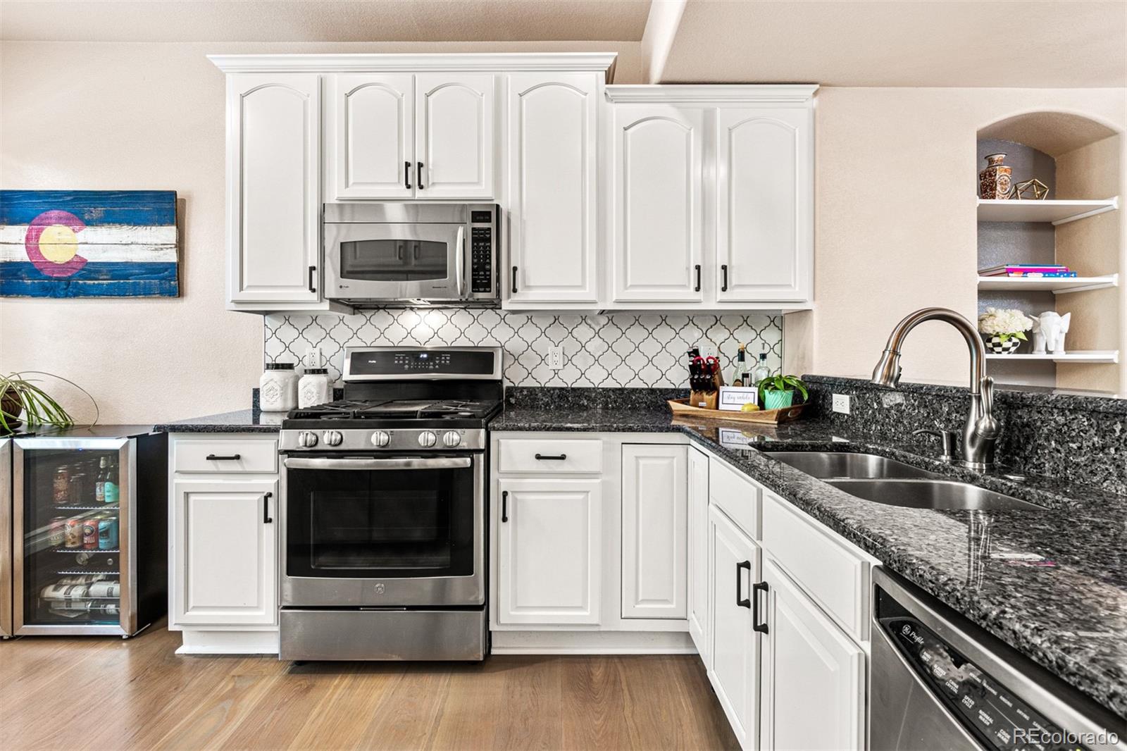 2323 Decatur Street Denver, CO 80211 - Photo 4 of 40 a kitchen with stainless steel appliances granite countertop a stove a sink and a microwave