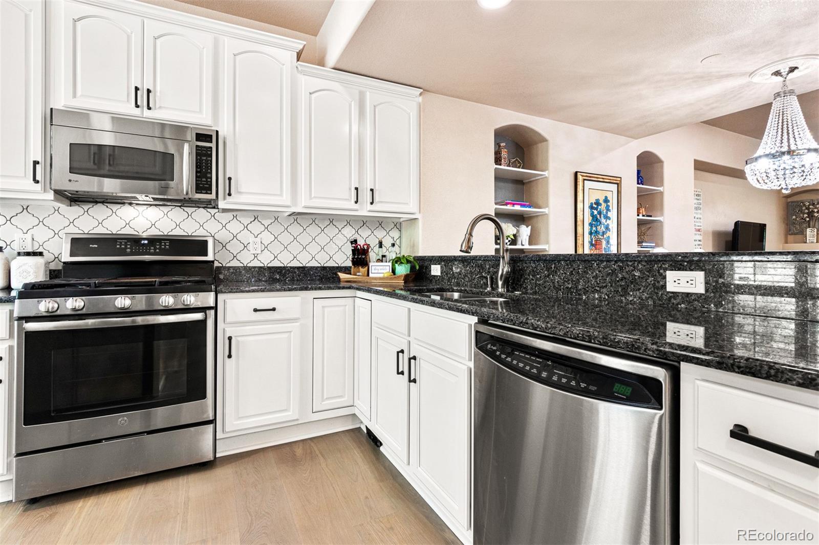 2323 Decatur Street Denver, CO 80211 - Photo 6 of 40 a kitchen with stainless steel appliances granite countertop a stove microwave and sink