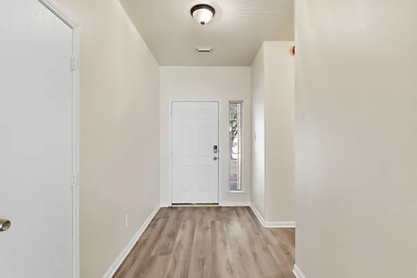 a view of a hallway with wooden floor