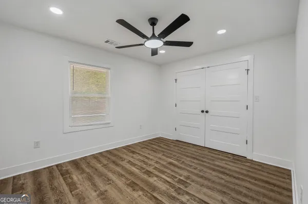 an empty room with closet and windows