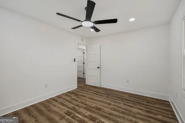 a view of a room with wooden floor and a ceiling fan