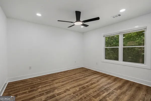 an empty room with a window and ceiling fan