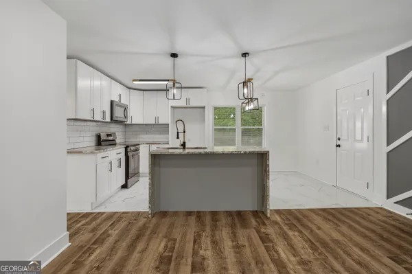 a kitchen with kitchen island white cabinets and refrigerator