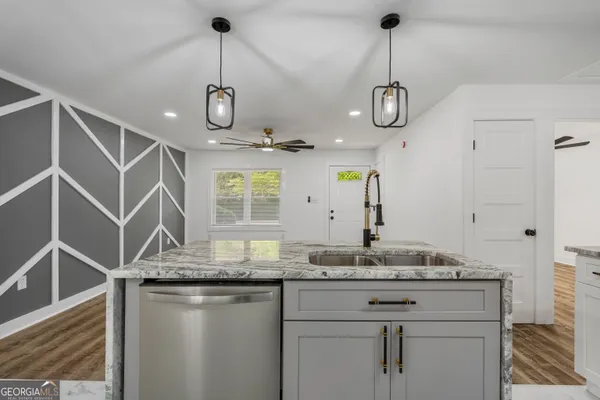 a kitchen with kitchen island granite countertop stainless steel appliances a sink and wooden floor