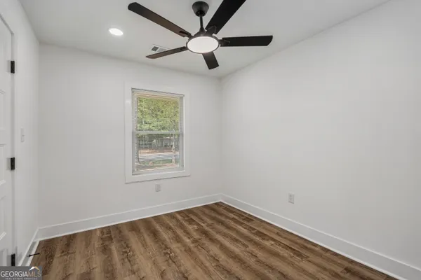 an empty room with a window and a fan