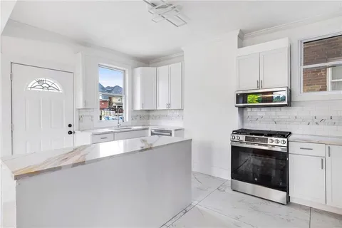 a kitchen with stainless steel appliances a stove a sink and a microwave