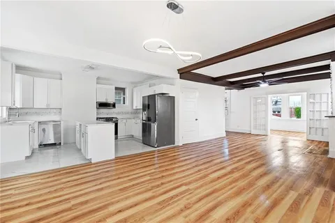 a view of a kitchen with cabinets and wooden floor