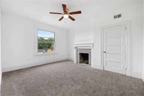 an empty room with a window and a fan