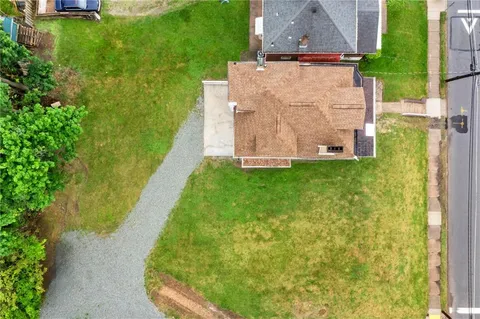an aerial view of residential houses with outdoor space and parking