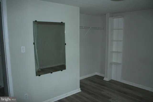 an empty room with wooden floor and closet