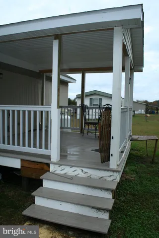 a view of a porch with furniture and a yard