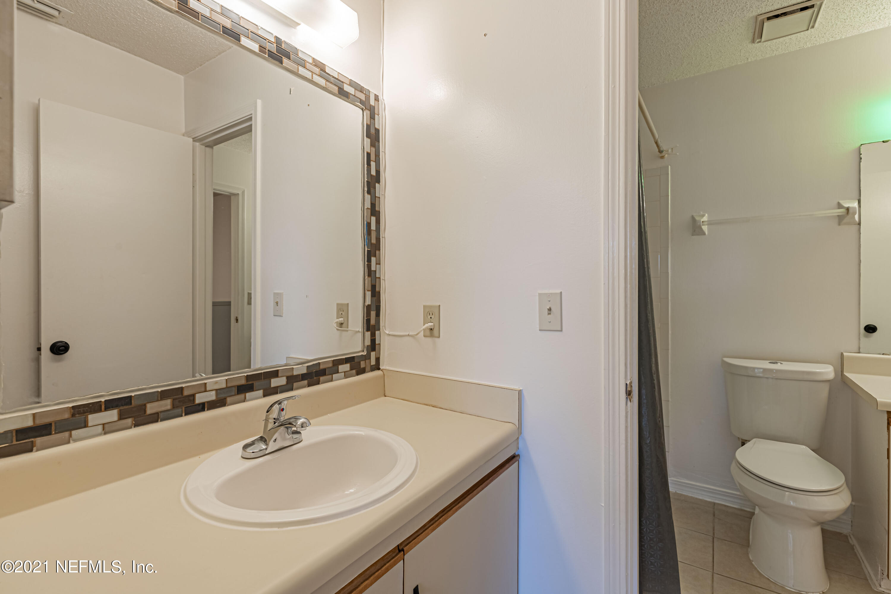 3517 Peeler Road, Unit 8 Jacksonville, FL 32277 - Photo 18 of 29 a bathroom with a toilet sink and mirror