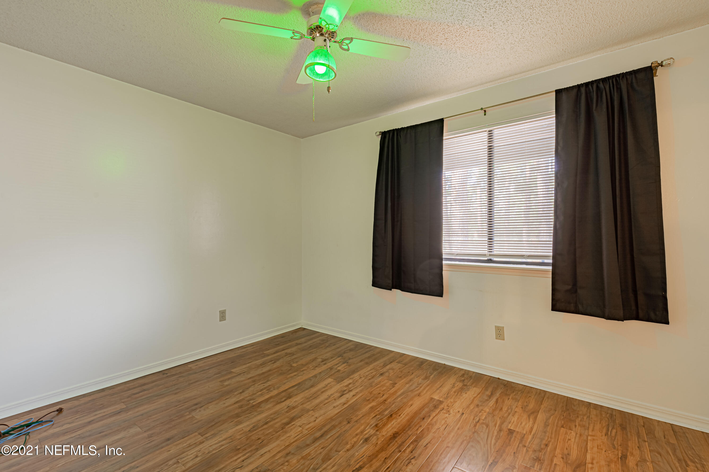 3517 Peeler Road, Unit 8 Jacksonville, FL 32277 - Photo 20 of 29 a view of an empty room with window and wooden floor