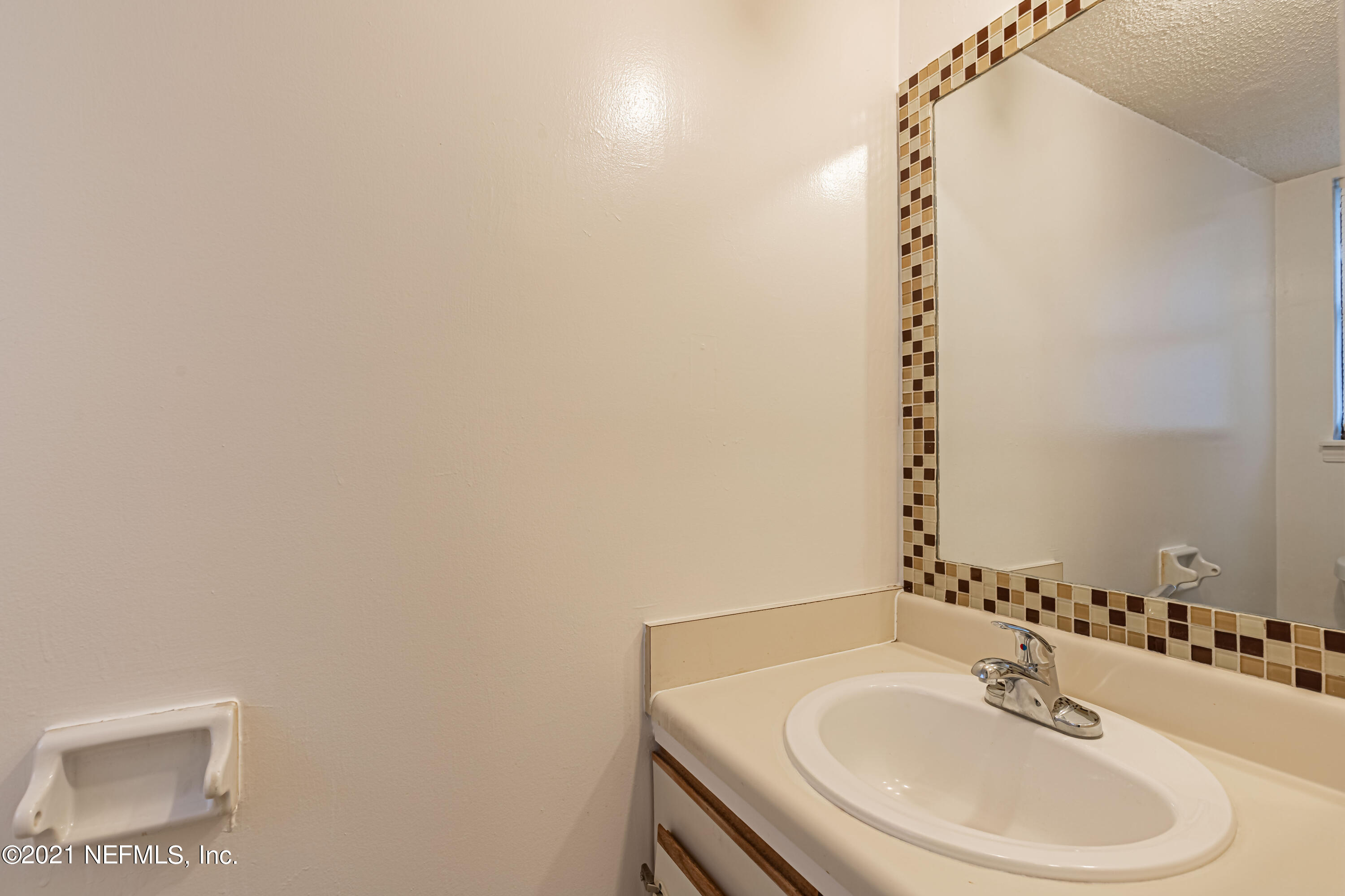 3517 Peeler Road, Unit 8 Jacksonville, FL 32277 - Photo 23 of 29 a bathroom with a sink and a mirror