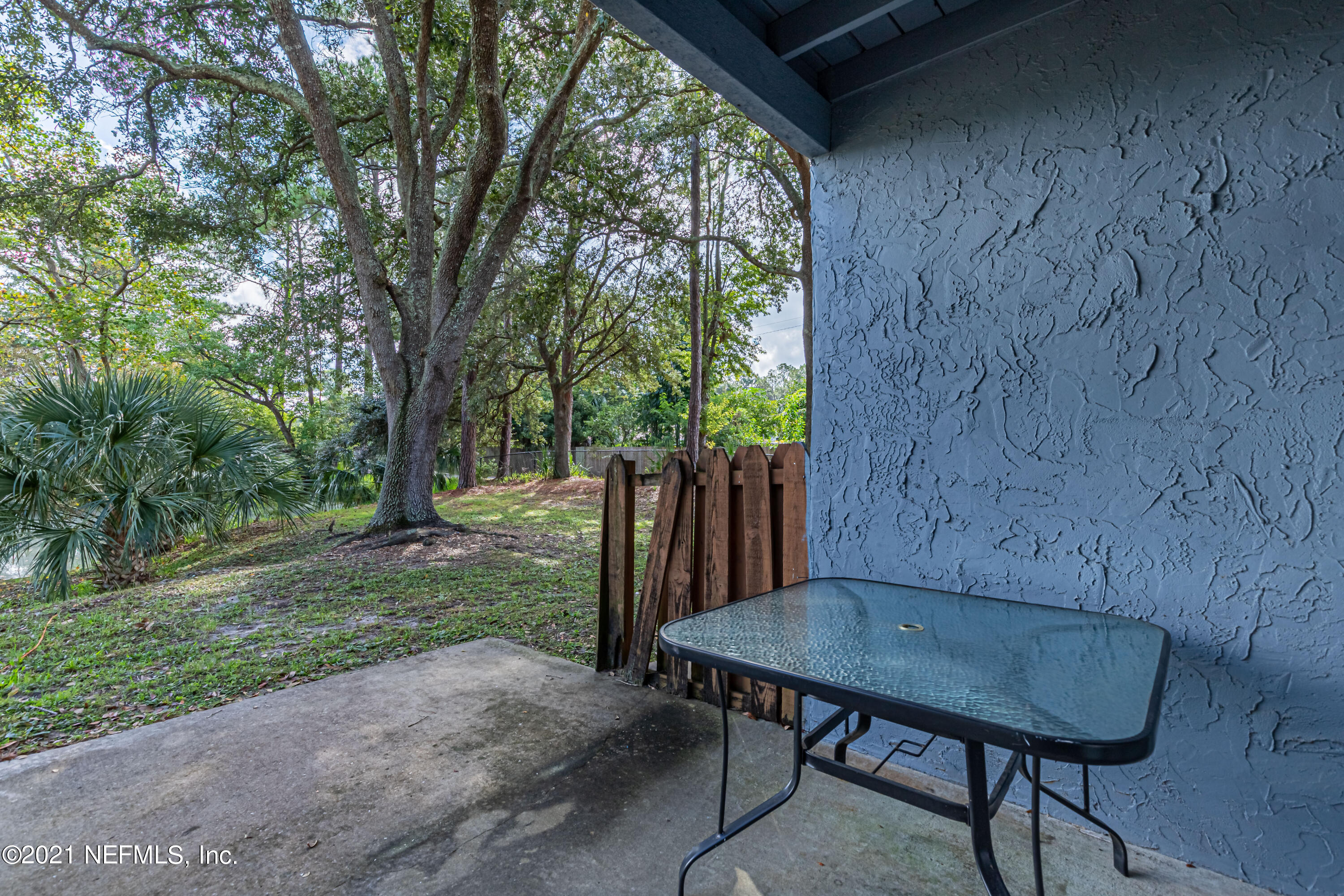 3517 Peeler Road, Unit 8 Jacksonville, FL 32277 - Photo 24 of 29 a view of a backyard with table and chairs and a barbeque with wooden fence