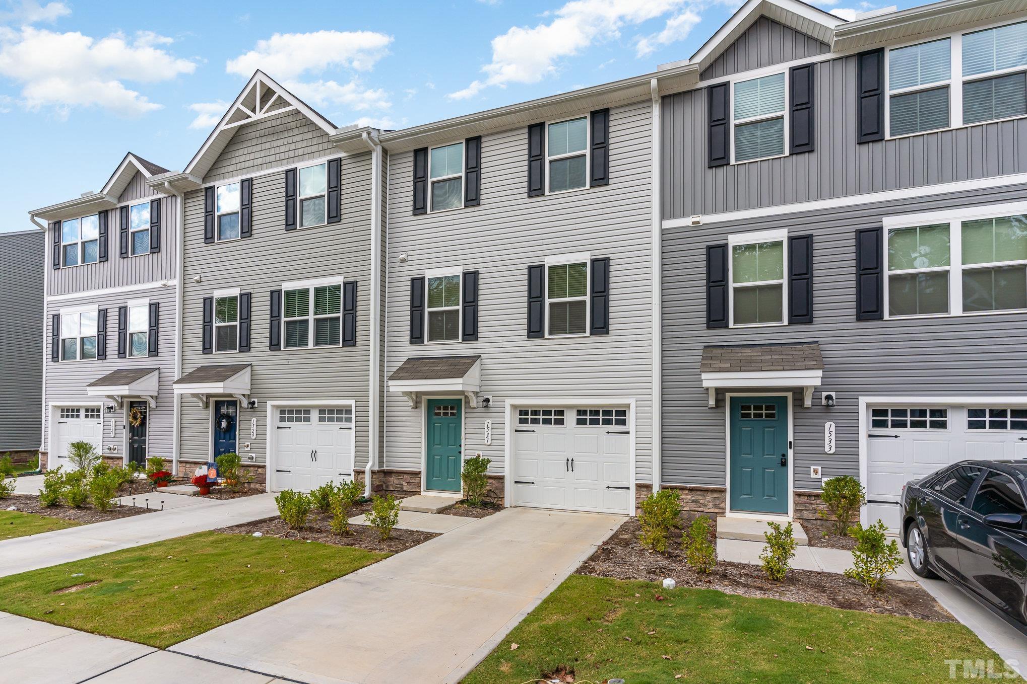 a front view of a building with a garden and plants