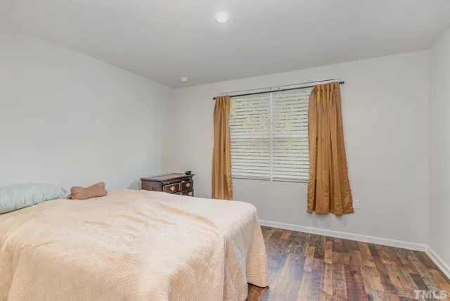 a bedroom with a bed and a flat tv screen on wall
