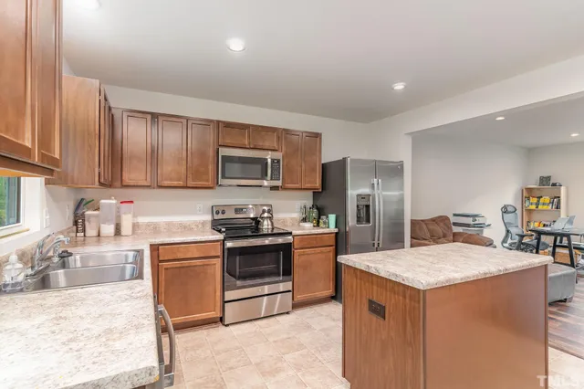 a kitchen with a sink stove top oven and refrigerator