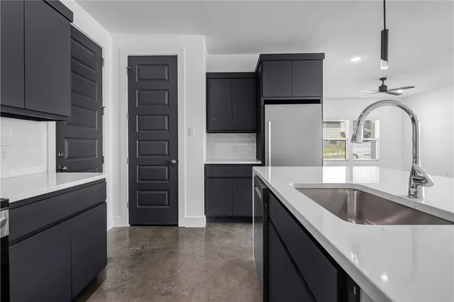 a kitchen with a refrigerator sink and cabinets