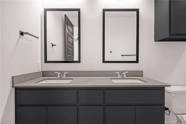 a bathroom with a double vanity sink and a mirror