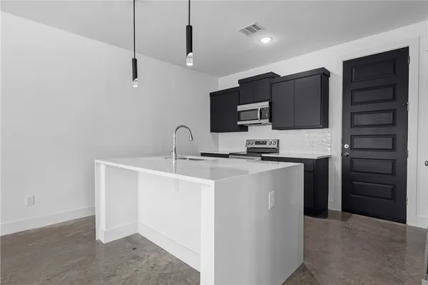 a kitchen with kitchen island a sink stainless steel appliances and cabinets