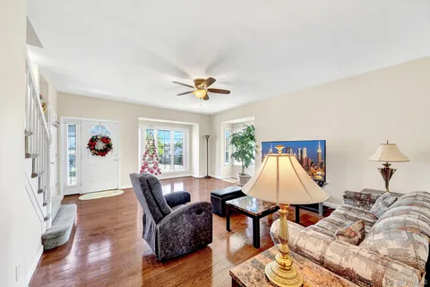 a living room with furniture ceiling fan and a wooden floor