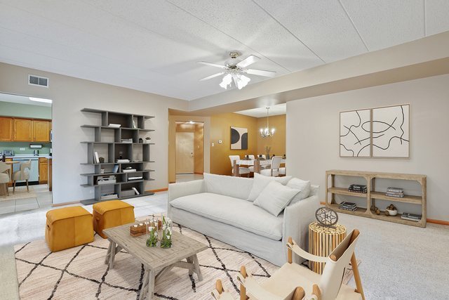 7825 Bristol Park Drive, Unit 1C Tinley Park, IL 60477 - Photo 5 of 22 a living room with furniture and a chandelier
