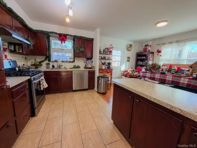 a kitchen with stainless steel appliances granite countertop a sink stove and cabinets