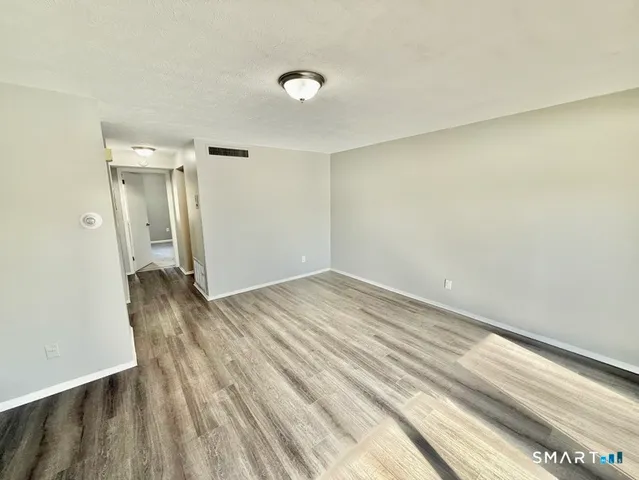 a view of a room with wooden floor and bathroom