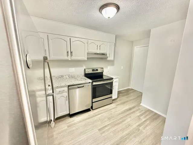 a kitchen with stainless steel appliances white cabinets and a refrigerator