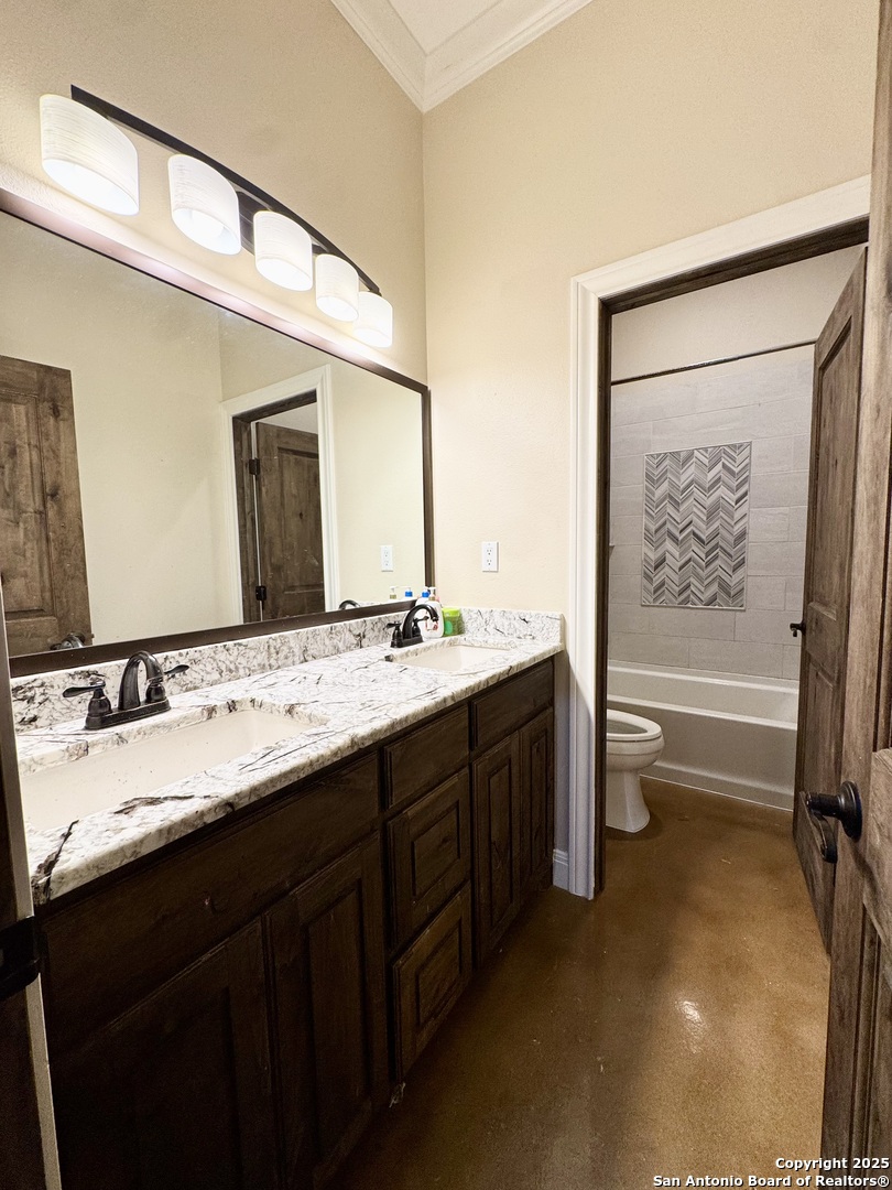 16489 Farm To Market Road 472 Devine, TX 78016 - Photo 20 of 31 a bathroom with a double vanity sink a toilet and a bathtub