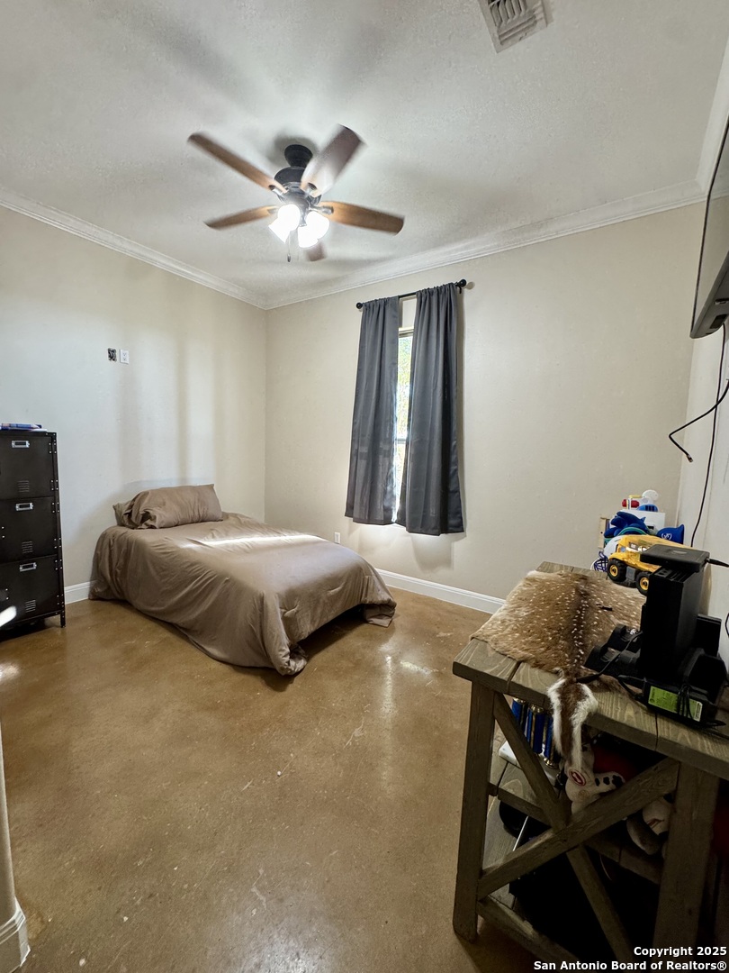 16489 Farm To Market Road 472 Devine, TX 78016 - Photo 22 of 31 a bedroom with a bed and window