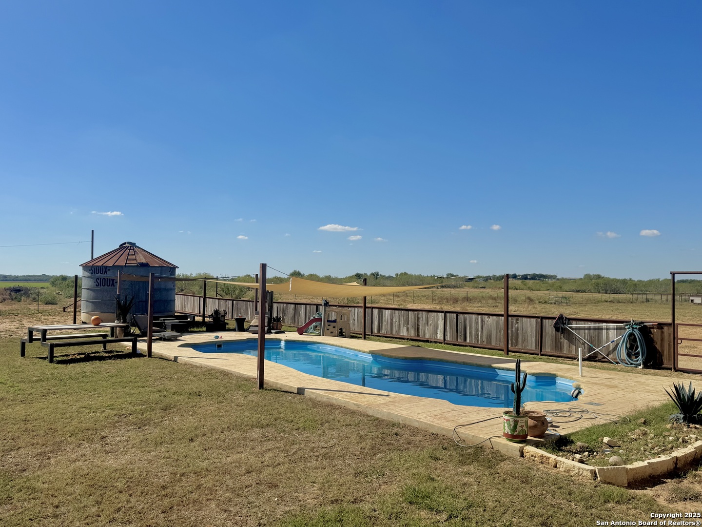 16489 Farm To Market Road 472 Devine, TX 78016 - Photo 5 of 31 a view of a swimming pool with a lounge chair