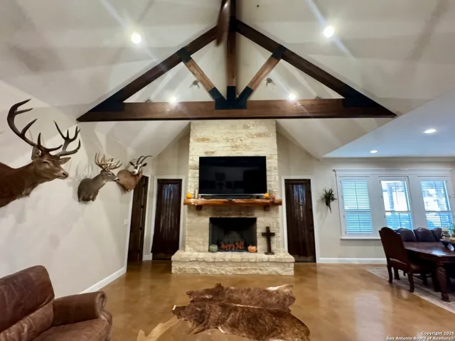 a living room with furniture a flat screen tv and a fireplace