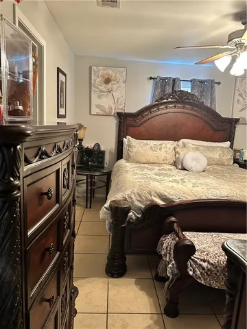 a bed sitting in a bedroom and dressers next to a window