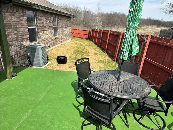 a backyard of a house with table and chairs