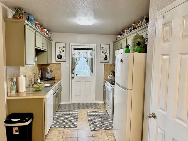 a kitchen with a refrigerator a stove a washer and dryer