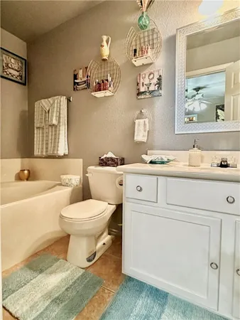 a bathroom with a granite countertop toilet sink and mirror
